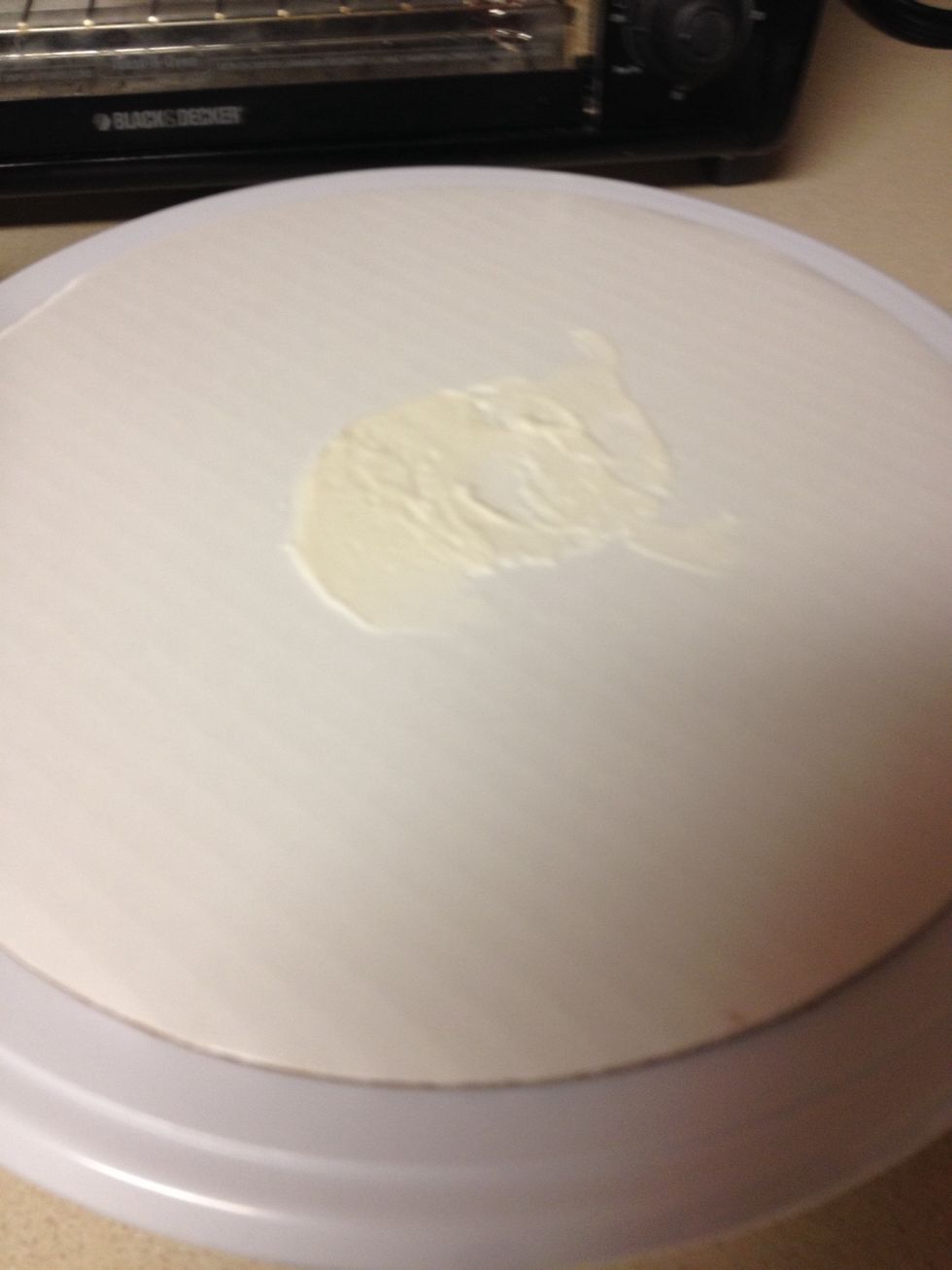 Place a small amount of the uncolored icing on the base so the cake will stick