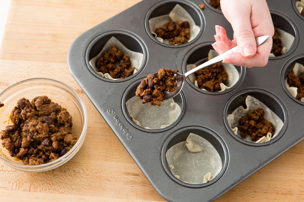 Place a small tablespoon of the meat mixture in each muffin cup.