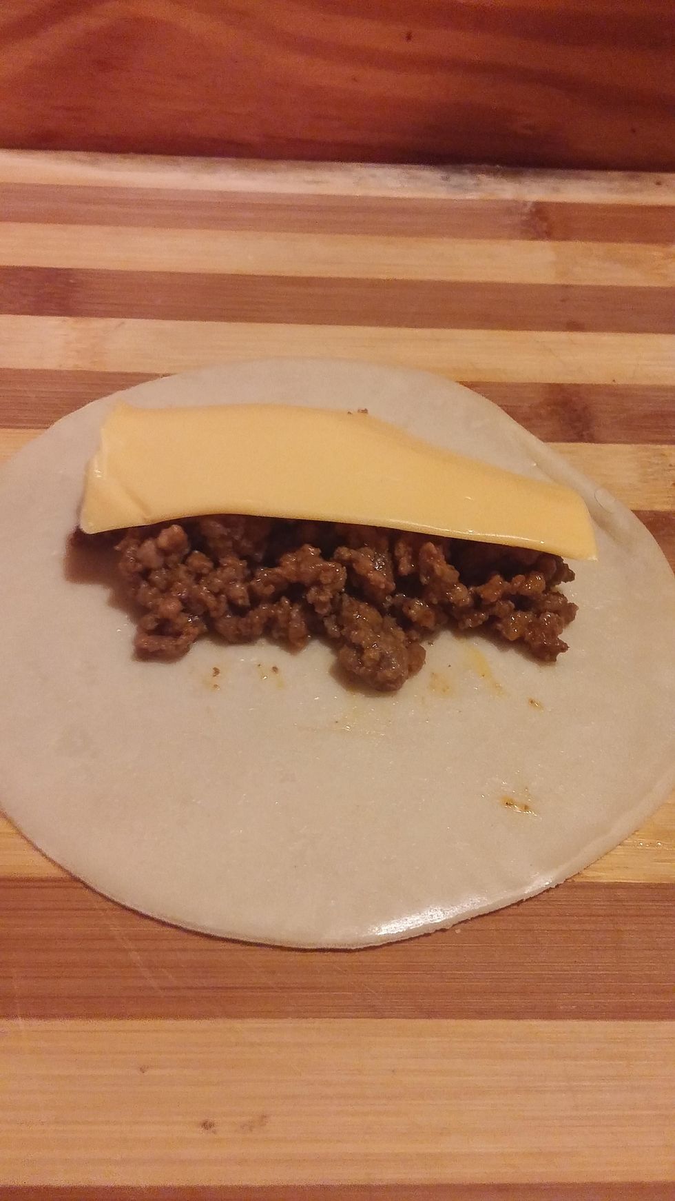 place a spoon of meat onto the disc on top, place half of a slice of American Cheese