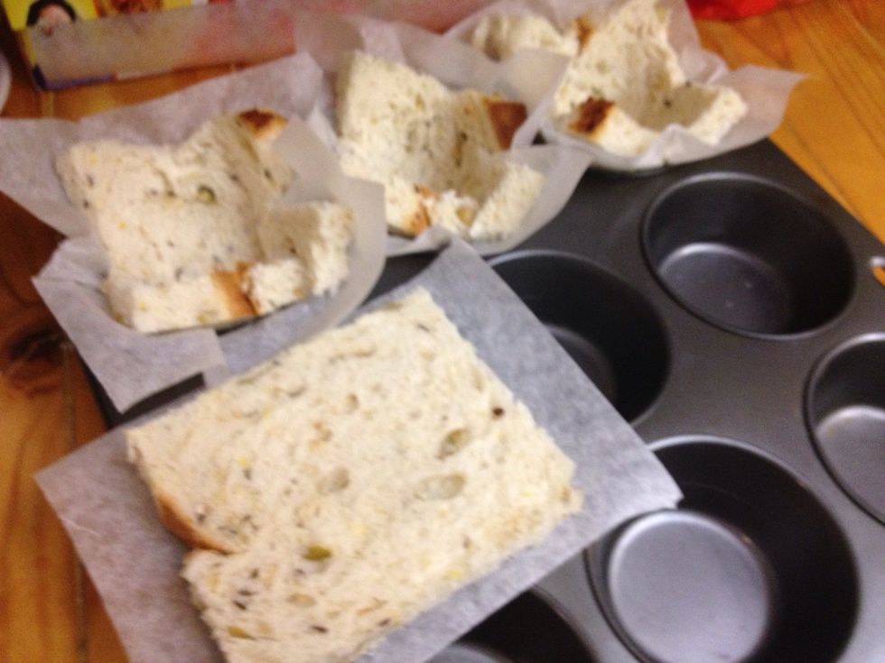 Place a square of baking paper under a slice of bread and press into the muffin tray. Continue with each slice. Then bake in oven for 20 mins at 180 deg Celsius.
