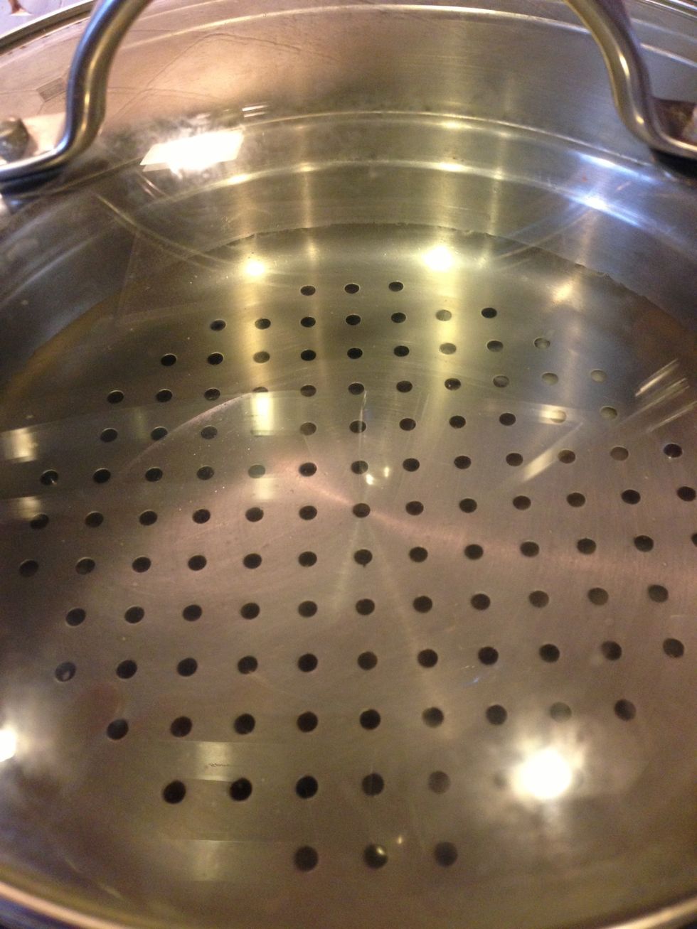 Place a steaming tray and lid on top. Be sure you can see some water through the holes. This will let you know when it is simmering.
