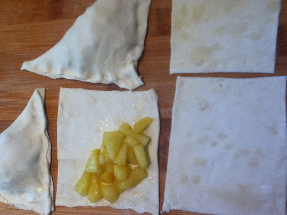 Place a tablespoon of the apples on one half of each square and fold to form a triangle