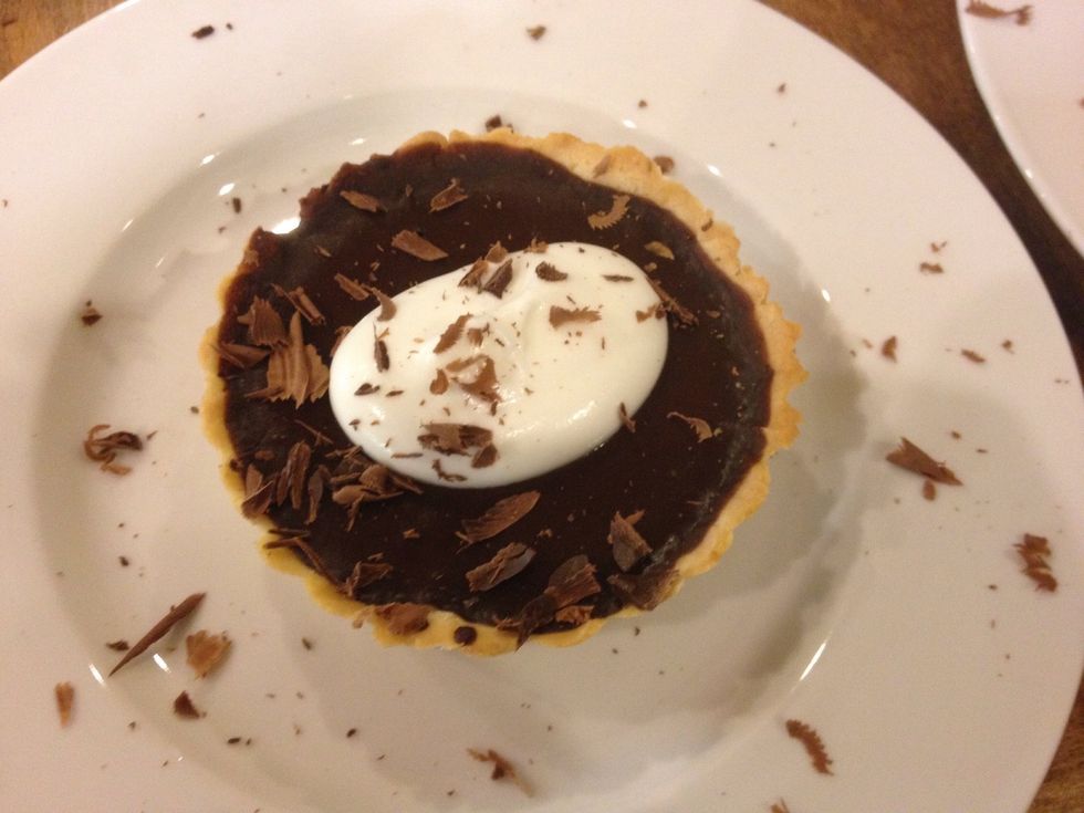 Place a tart on a plate place 1 spoon of whipped cream on top then drop some shavings serve to your hungry guests .. Well if u want to share that is .. :) please enjoy