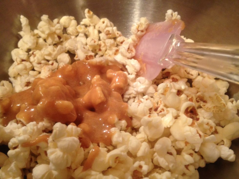 Place a third of the popcorn in your bowl and top with a third of the sauce. Mix until incorporated. Repeat until you've used all the sauce and popcorn. A rubber spatula works best.