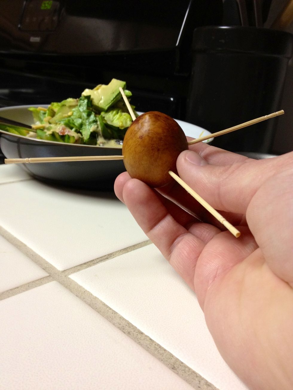Place a total of 4 toothpicks in the pit equidistant for each other - you'll see that this produces a nice, solid way to suspend your seed in the dish.