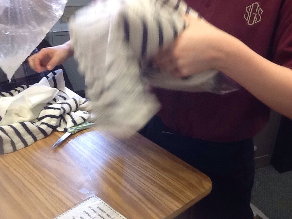 Place a towel around the bag of ice and shake .