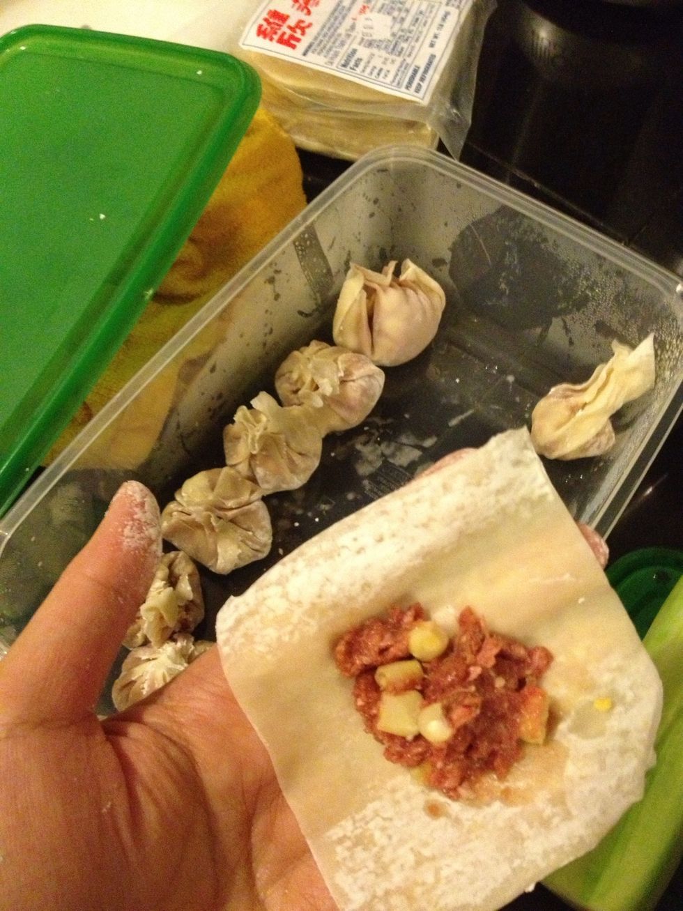 Place a tsp of the mixture of each wonton wrapper, and slightly moisten the edges of the wrapper with water. Seal the edges to form a triangle shape, then press the edges to thin out the dough.