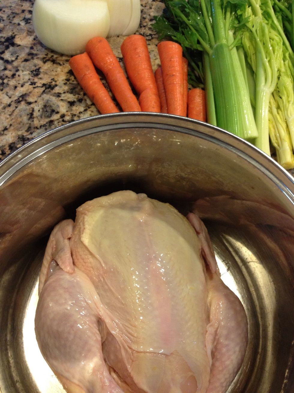 Place a whole chicken in a large pot, and add the veggies