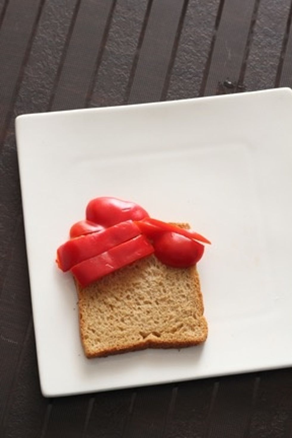 Place a wholewheat bread on a plate and arrange the pepper as shown .