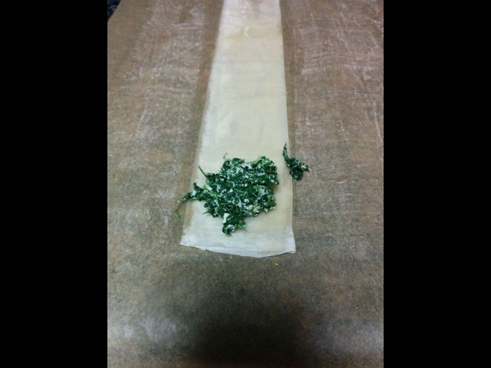 Place about one tablespoon of the spinach mixture at the end of the phyllo dough.