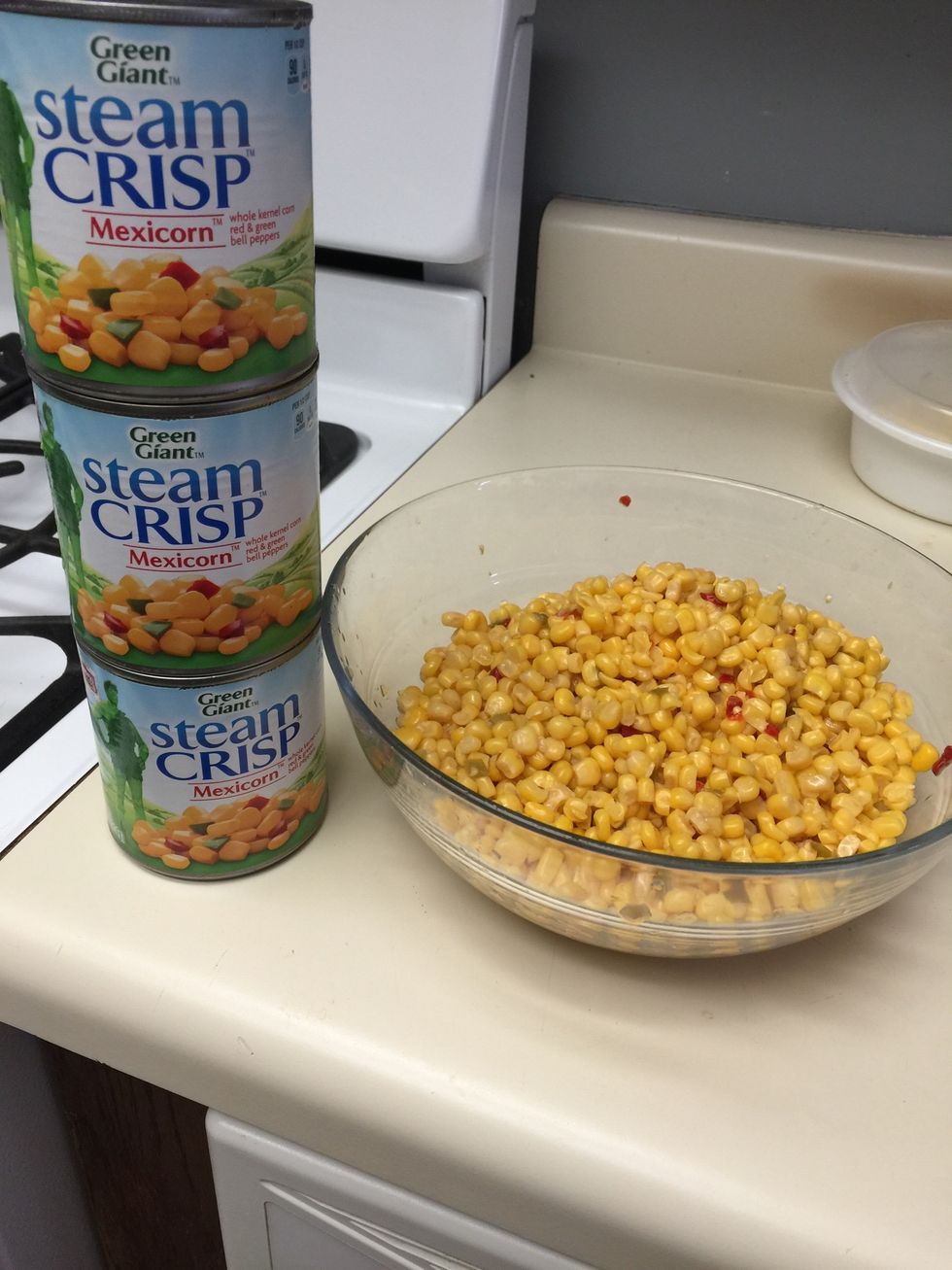 Place all cans of corn in large bowl.