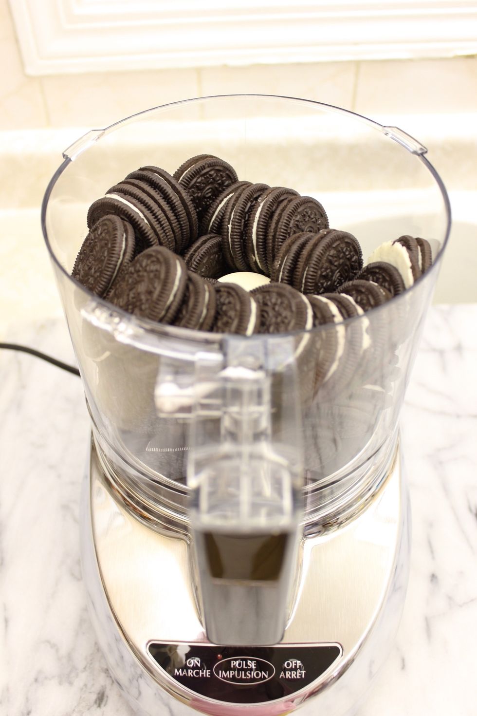 Place all of the Oreo cookies into a food processor fitted with the blade attachment.