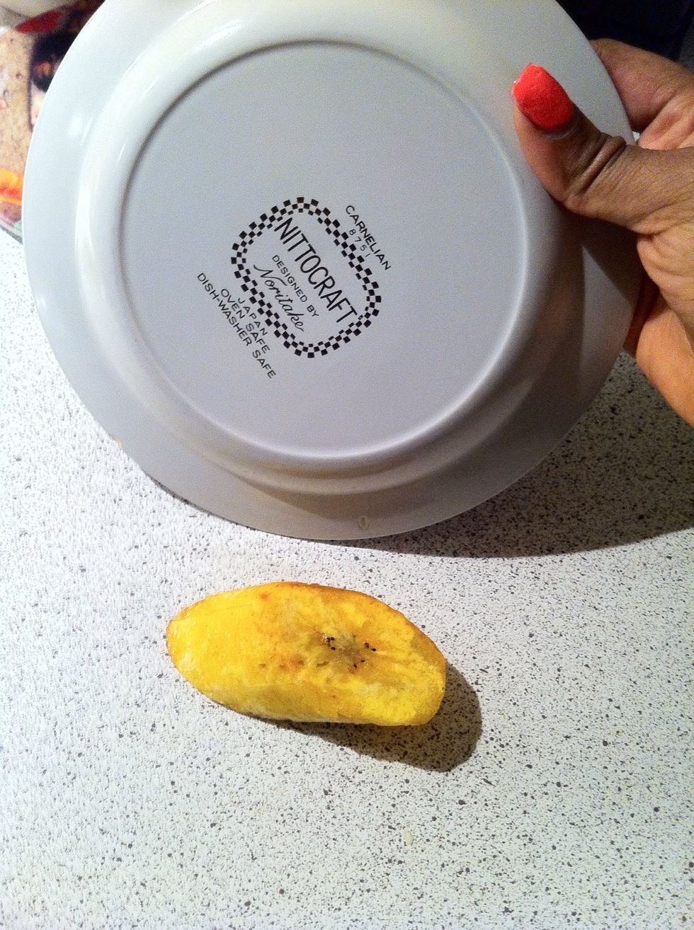 Place all your plantain in a bowl. Take one, place it on a flat surface. Take a flat plate and press on it. Not to hard just enough force to flatten it a bit