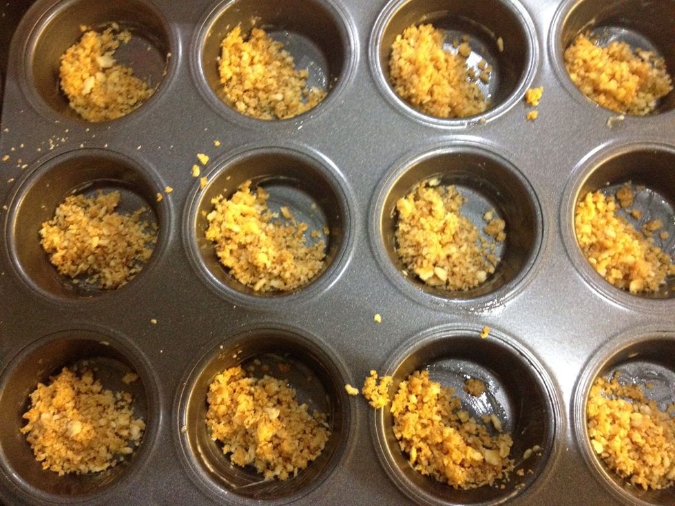 Place an equal amount (I used a one tbsp measure) of the crust in each 'cup'.