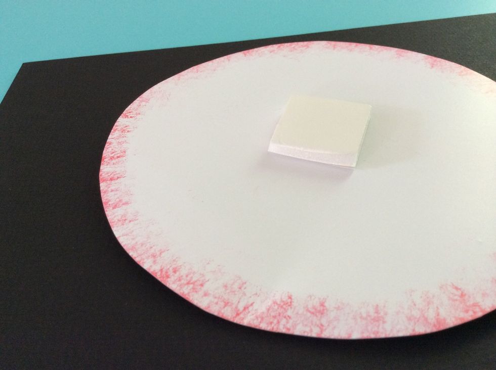 Place another 1" x 1" piece of foam board in the center of the large white poster board circle.