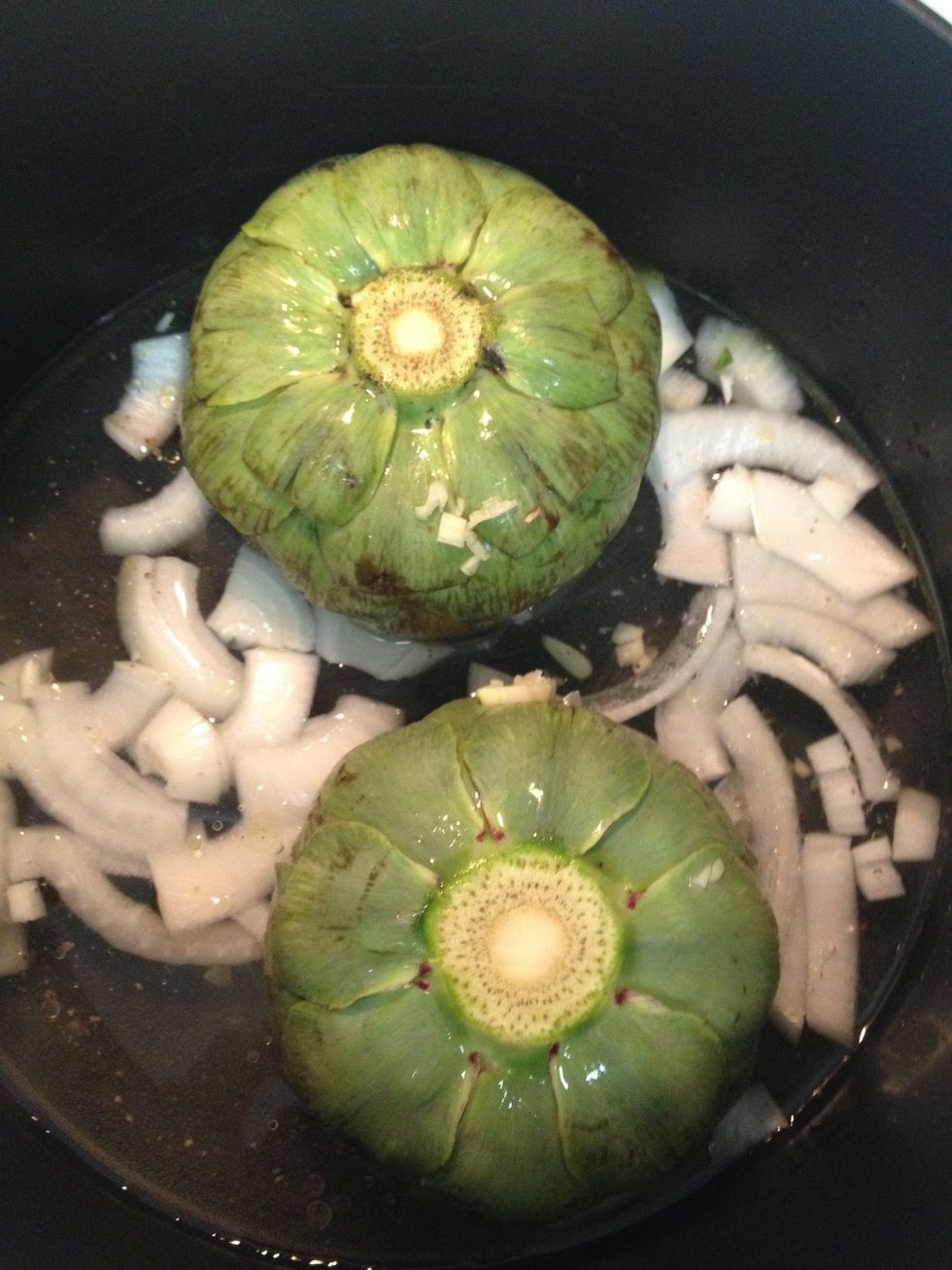 place artichokes in pot (fill an inch or two with water,) upside down (to steam,) with garlic and onions.