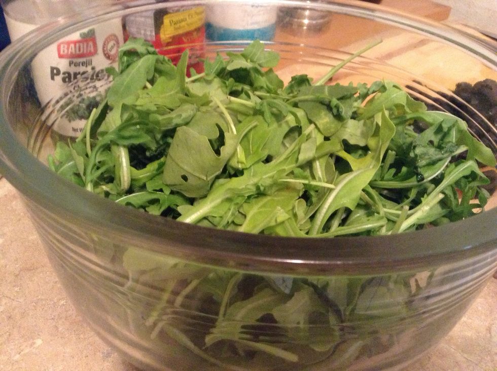 Place arugula in large salad bowl