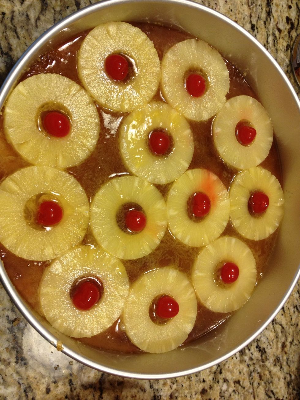 Place as many pineapple rings into the pan as you can.( I was able to place 12 pineapple slices into the pan). Than put a cherry in the center of each pineapple.
