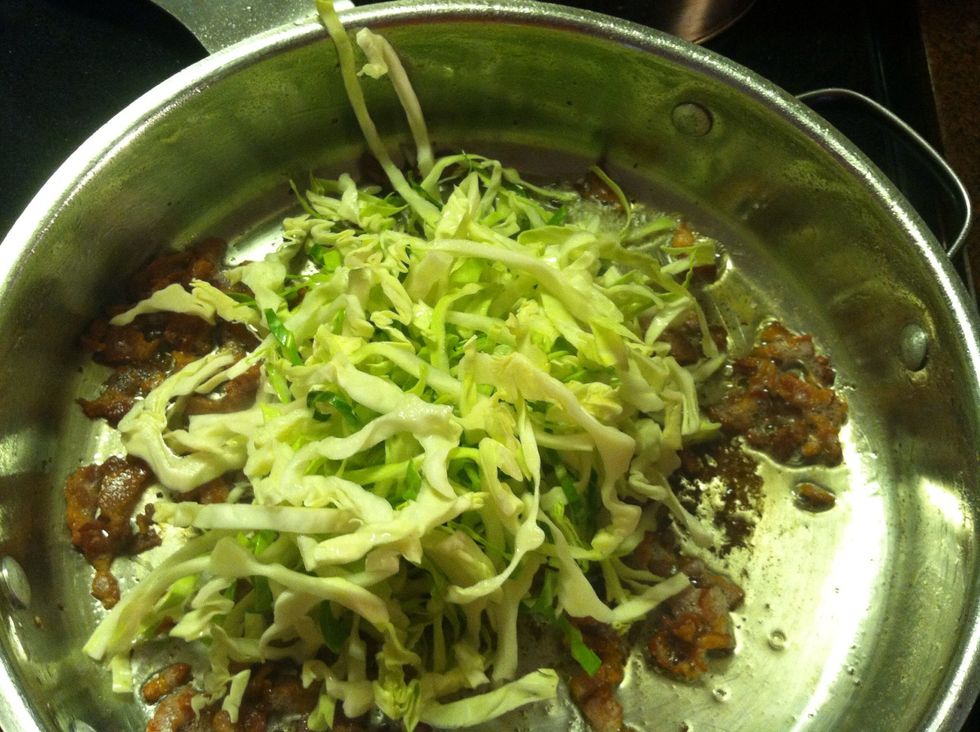 Place back on the heat - put raw cabbage on the bacon.