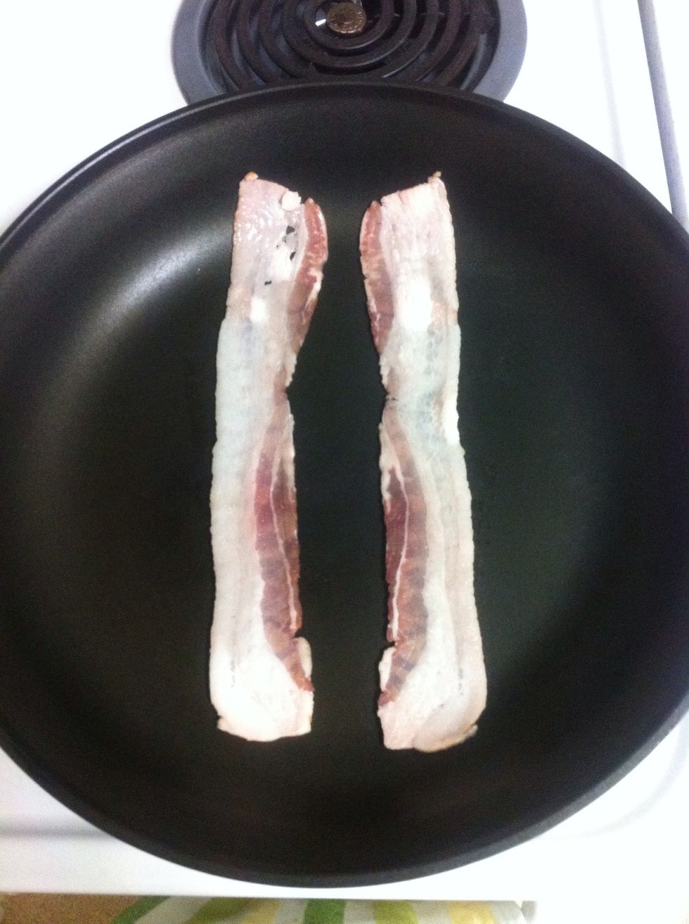 Place bacon in a pan and cook over medium heat