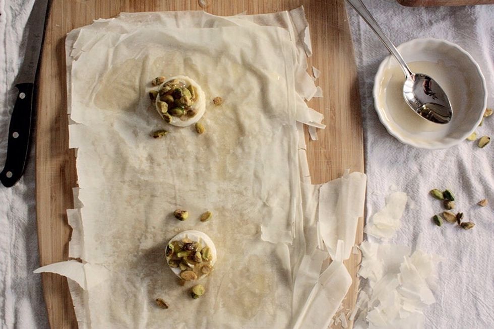 Place Brie rounds on phyllo dough (2 per rectangle work best), drizzle with honey, top with about 2tsp pistachios.