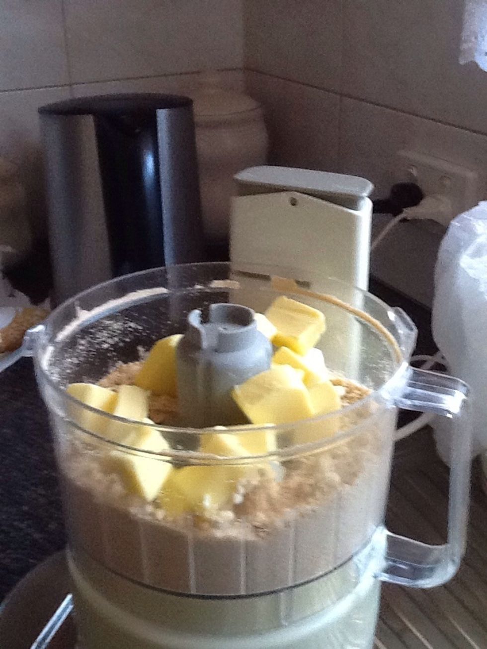 Place butter into mixer with biscuit crumbs and blend until well combined