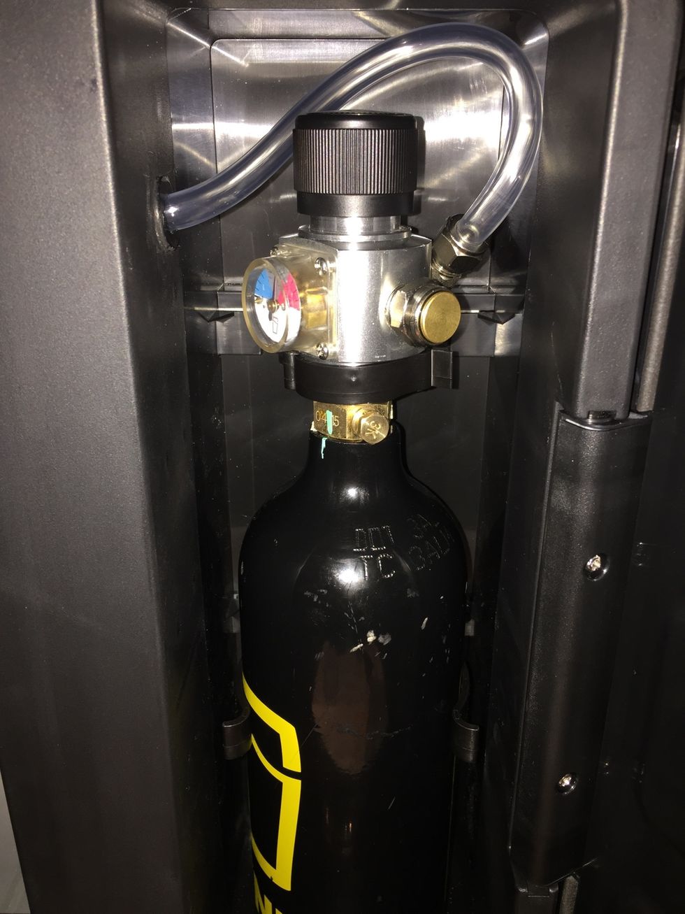 Place canister in side compartment. Make sure that the hose is not pinched. You can also pull and push the hose through the wall to create or remove slack. Lock canister in place.