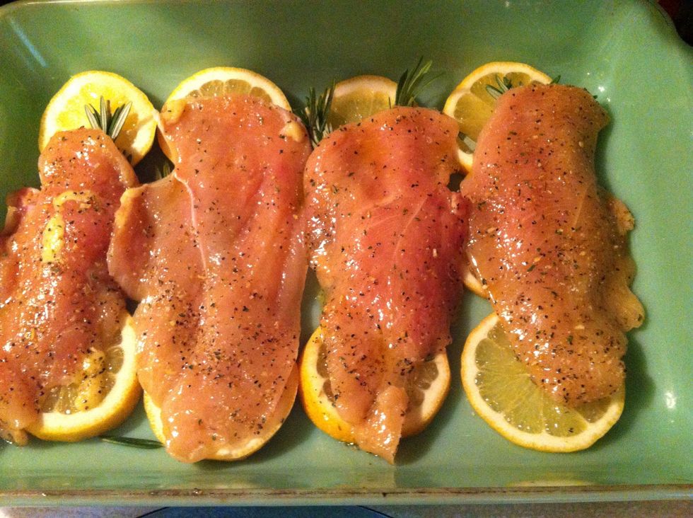 Place chicken on top of lemon slices and rosemary. And then add another sprig of rosemary and lemon slices on top of chicken.