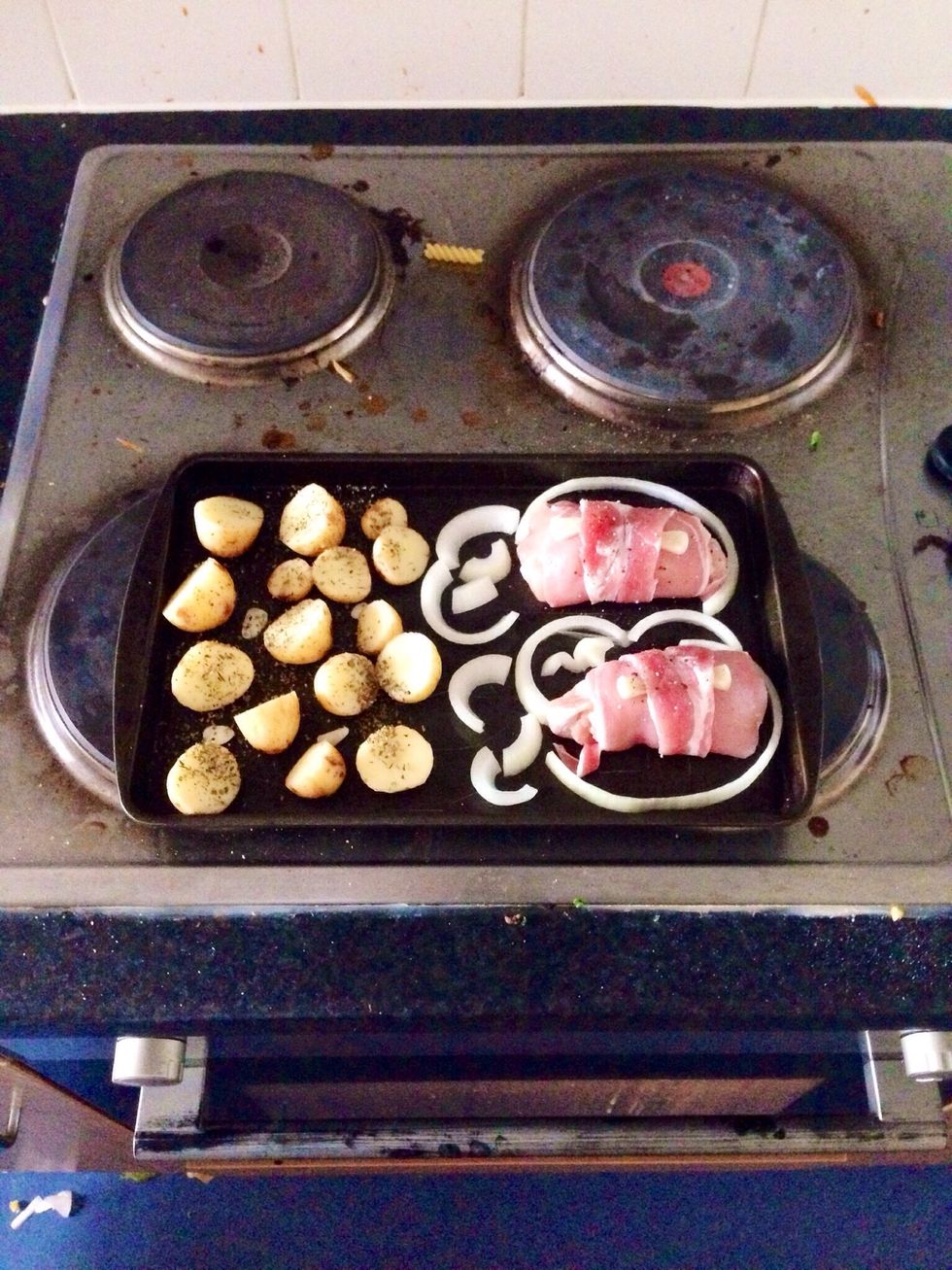 Place chopped potatoes and rolls on the tray. Put some garlic and onion around. Add some pepper and salt. Put tray in the oven (200C') for about 30 minutes (until potatoes baked).