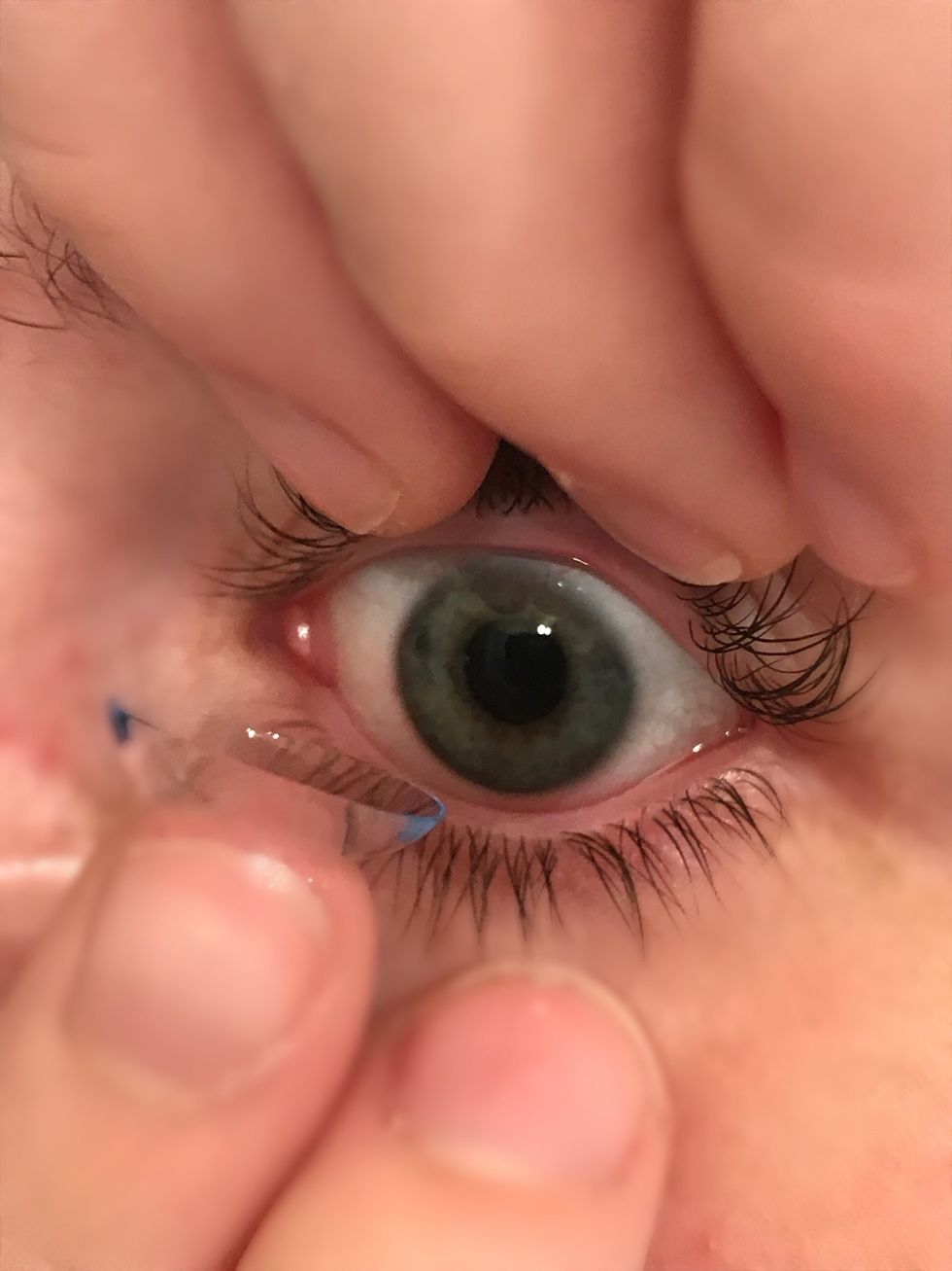 Place contact on the pupil and iris part of your eye and remove finger. Once you have done this role your eyes and blink a few times to be sure that it is in.