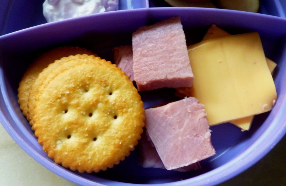 Place crackers, cheese slices and ham slices in large section of divided dish.