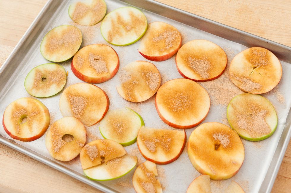 Place cut apple slices on a pan with wax paper or a silpat. A silpat will help keep them from sticking. It was harder with wax paper. Then, sprinkle one side with your cinnamon sugar mixture.