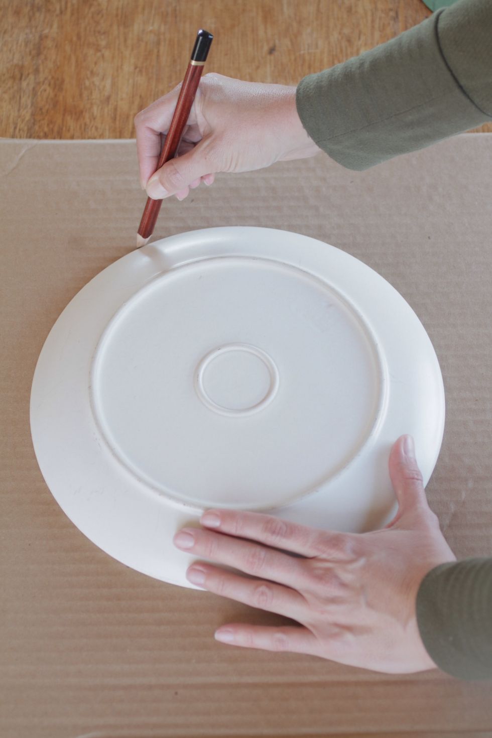 Place dinner plate upside down on the cardboard, and trace the edge of it with a pencil, leaving you with a large circle. (Or, use your trusty compass.)