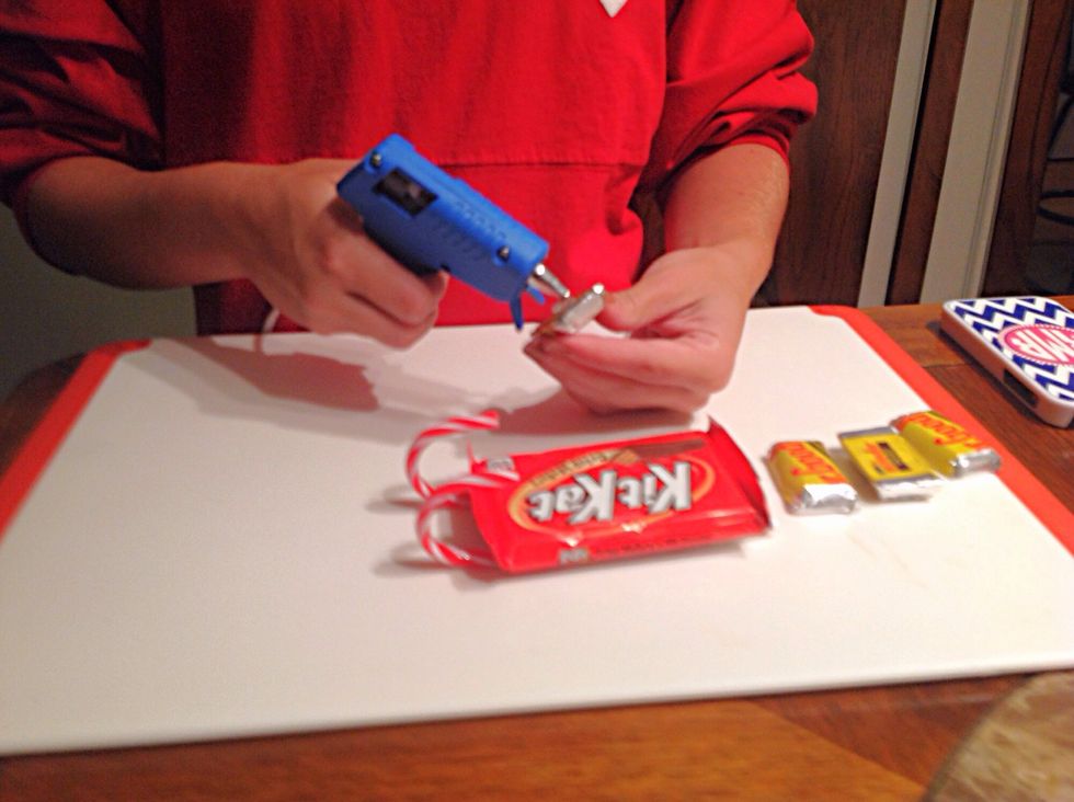 Place drops of hot glue on the bottom of the four Mr. Goodbars.