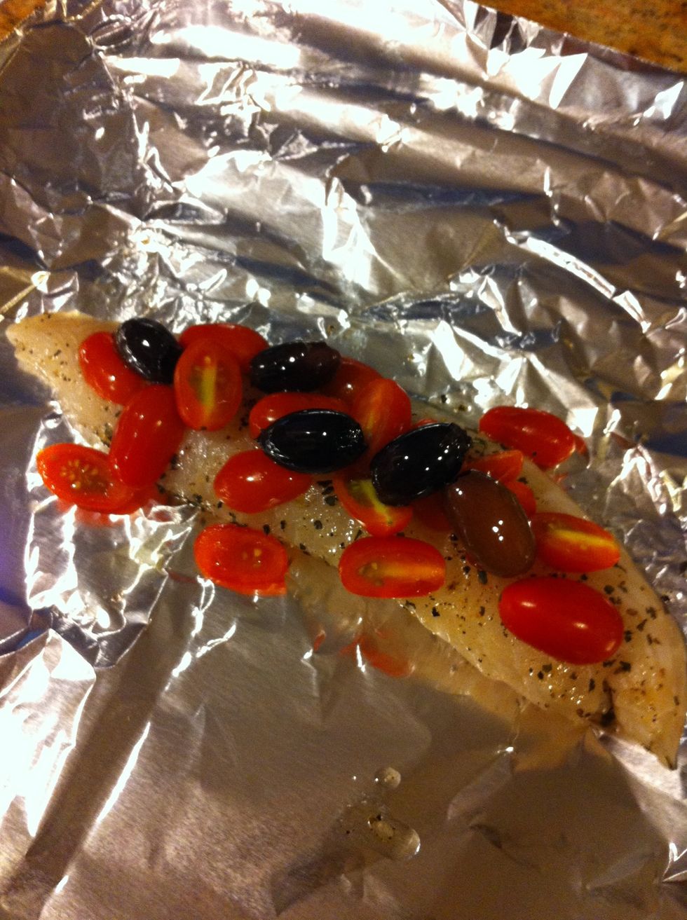 Place each tilapia on a large piece of foil. Add sliced red plum cherry tomatoes and olives.