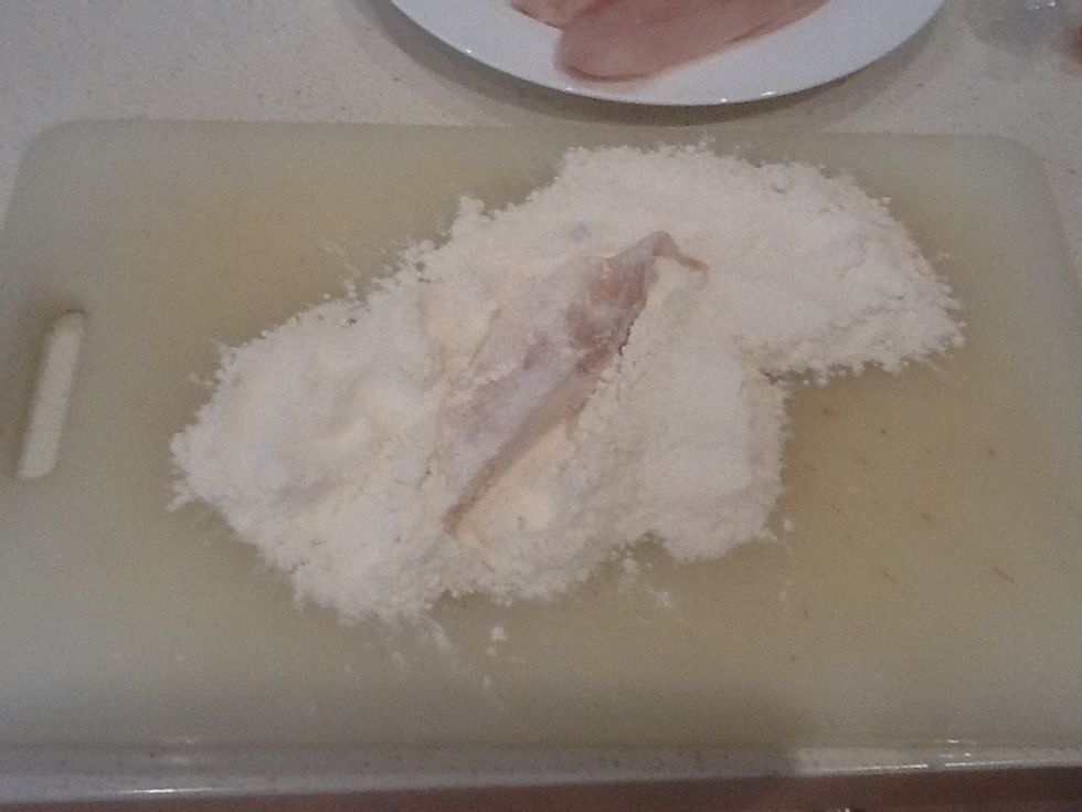 Place flour onto chopping board and cover the fish