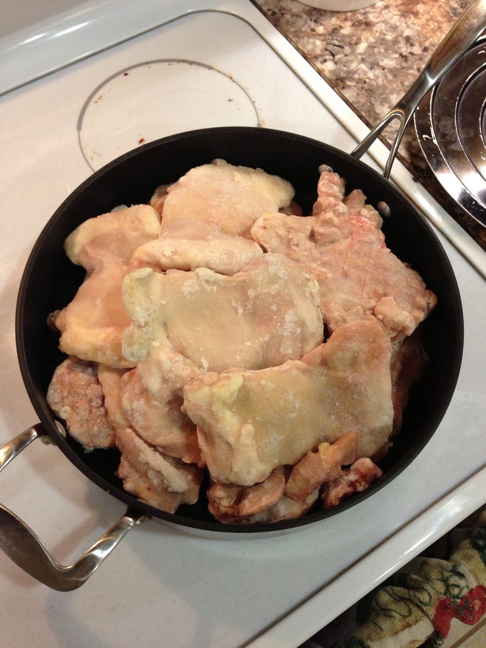 Place frozen chicken portions in large pan so they can begin to defrost and break apart