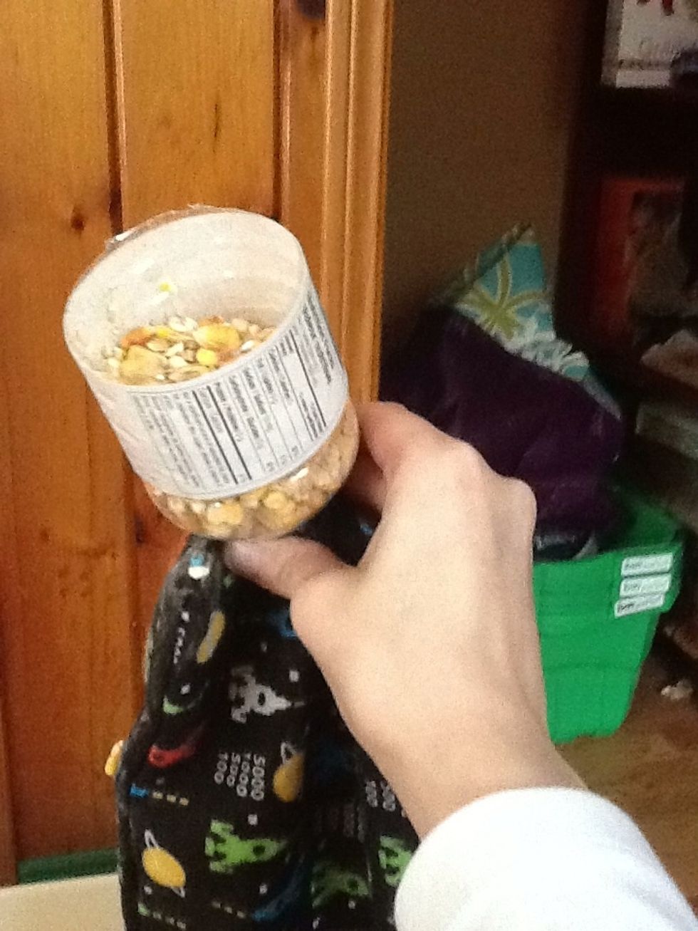 Place "funnel" neck inside the bag. Now start scooping corn into the bottle and fill the bag. You want to go about half way. Depending on the size and shape will depend on how much corn each bag takes