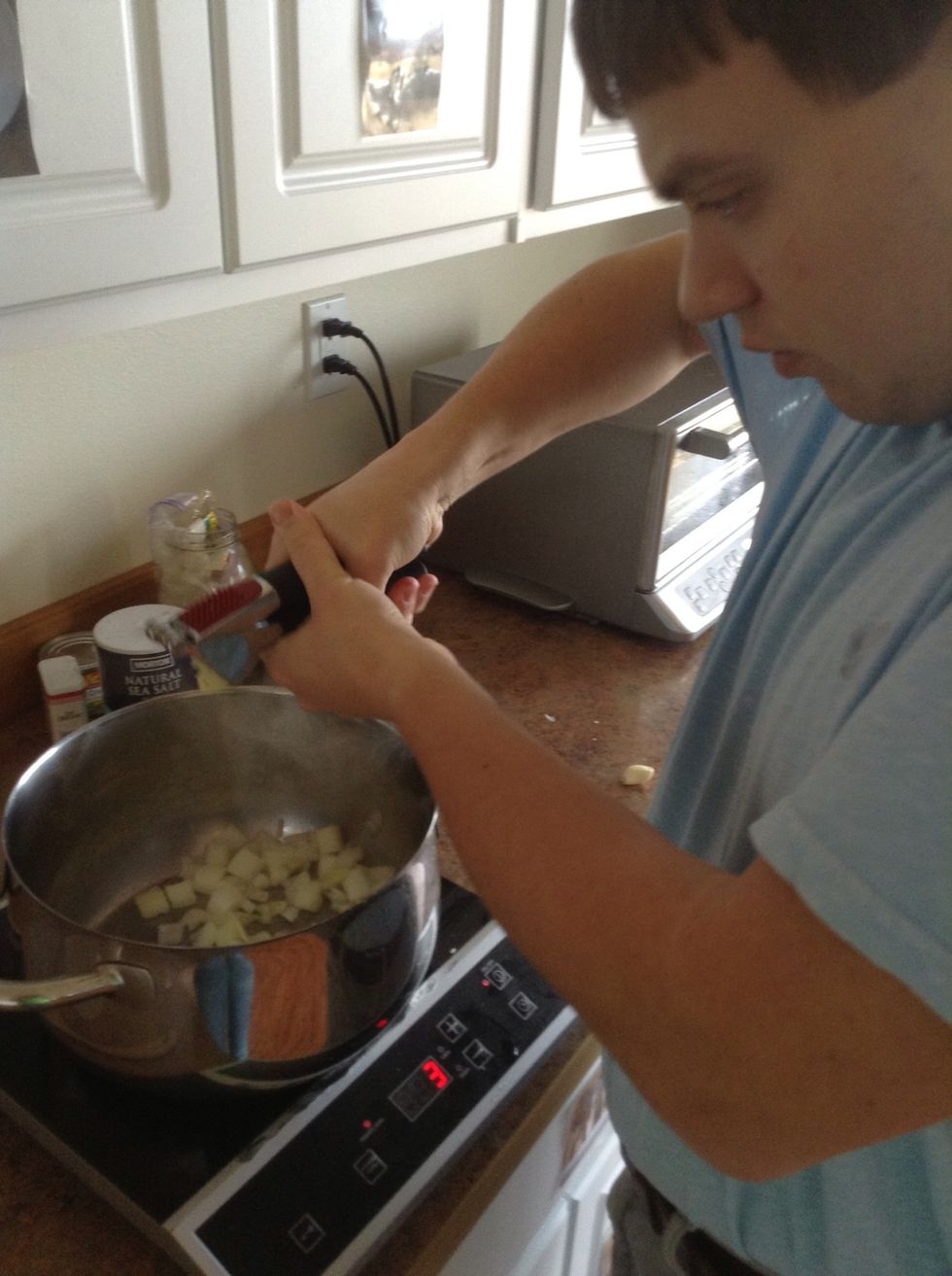 Place garlic cloves into chamber of garlic press. Hold garlic press over pot and squeeze handles together to mince the garlic