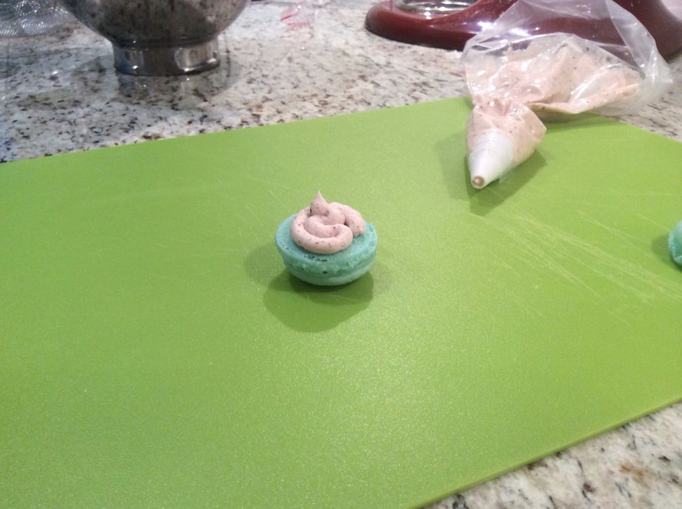 Place icing in a piping bag and pipe in between macarons and on top of your cupcakes (5 minutes)