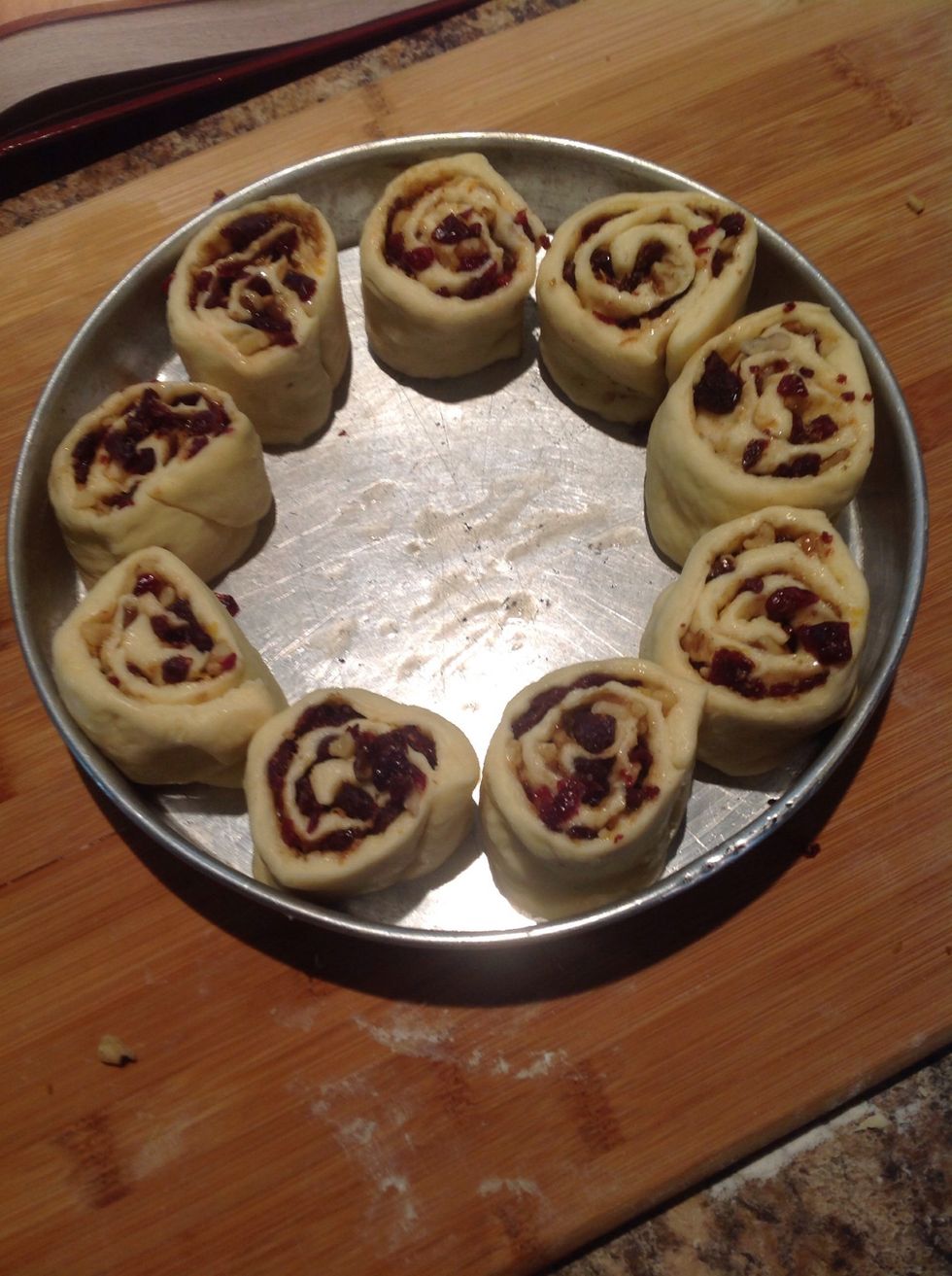 Place in a buttered cake pan. Cover and let sit until doubled in volume. Brush with milk and place in the oven at 375F for 25 min