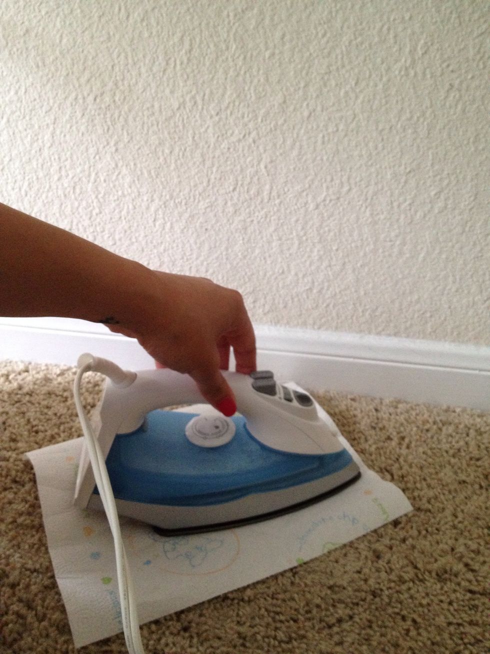 Place iron on top of wax for a few seconds. Don't press too hard on the iron. You won't burn the carpet or towel as long as you pay attention.