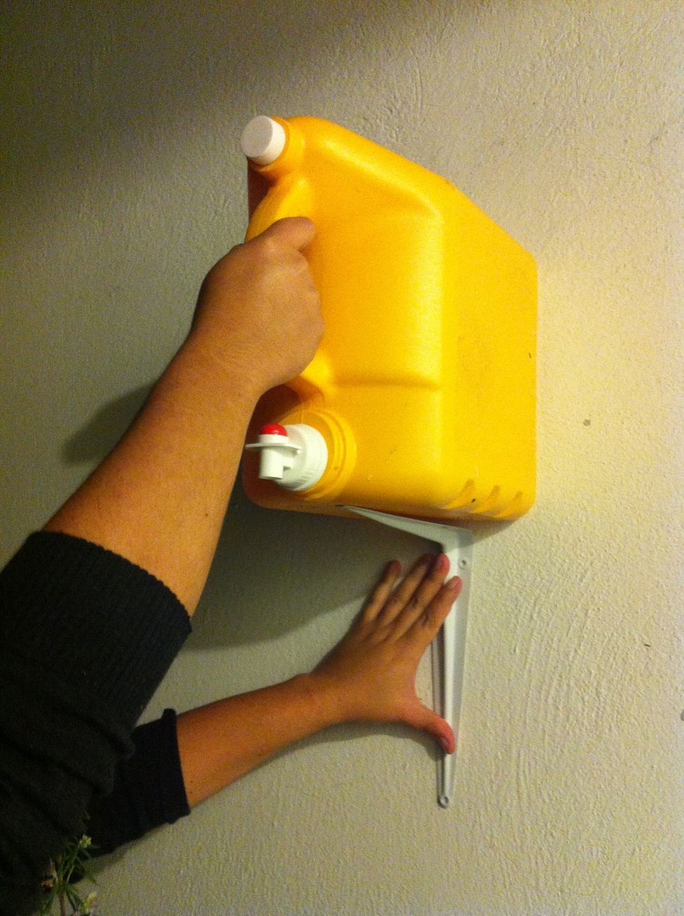 Place it and secure it as shown with the duct tape, the drill and the screws. Make sure you dont drill into the container.