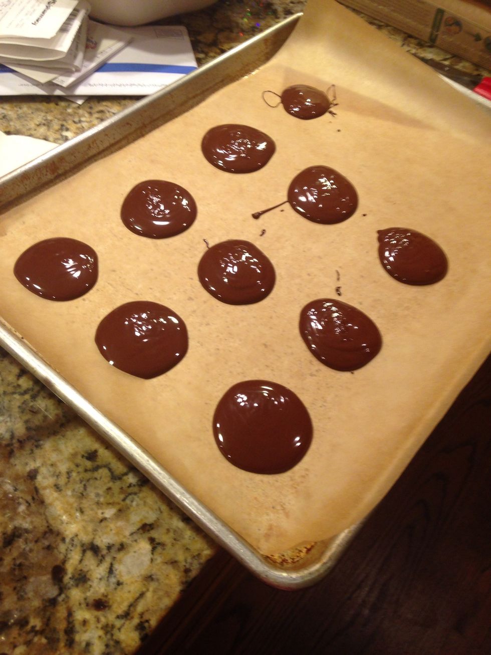 Place large circles of chocolate on the wax paper. Careful, the chocolate will spread out when the almonds are added, so space them out!
