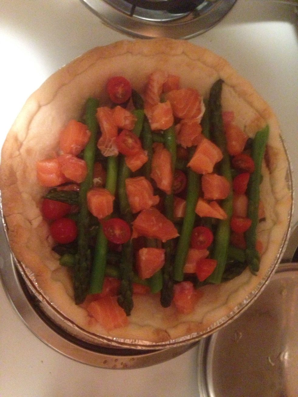 Place layer of asparagus and salmon with cherry tomato