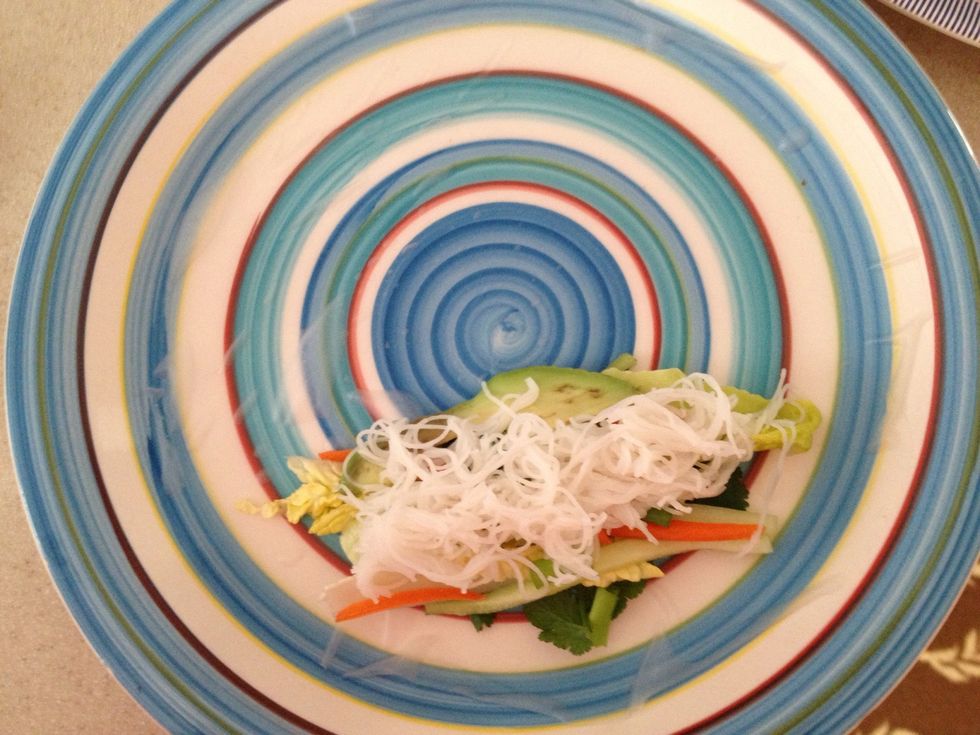 Place lettuce, veggies, avocado, and rice noodles on top.