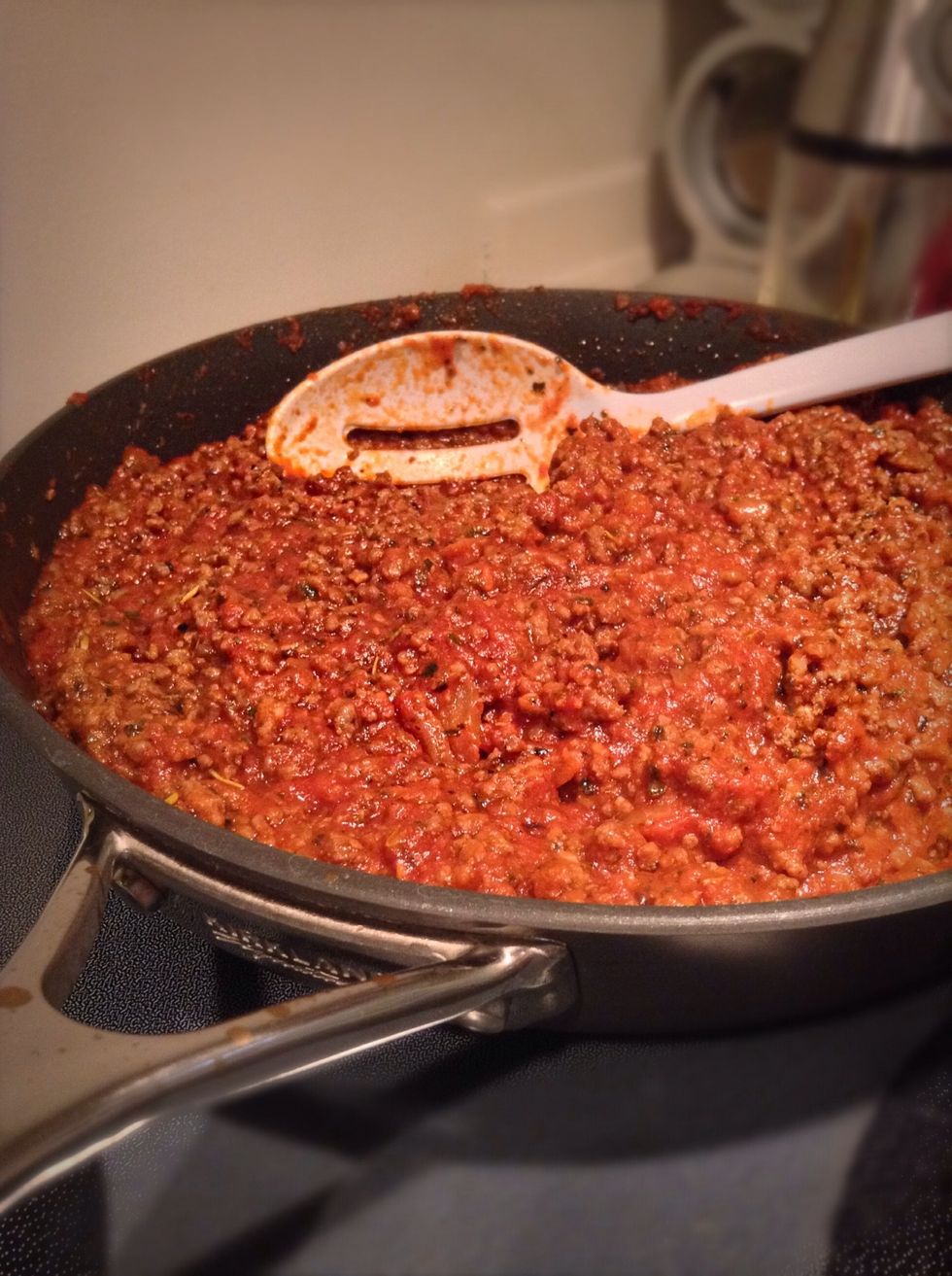 Place meat back into the pan, add in your pasta sauce, sugar, tomato paste and salt. Stir the mixture and place on the back burner on low for 30 minutes. This will allow the mixture to thicken.