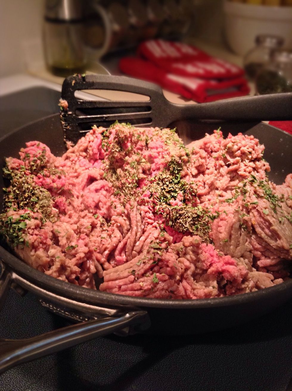 Place meat, onion, garlic, 1 tablespoon of parsley, 1 tablespoon of basil, 1 tablespoon of garlic salt and 1 1/2 tablespoons of Italian seasoning on medium to high heat.