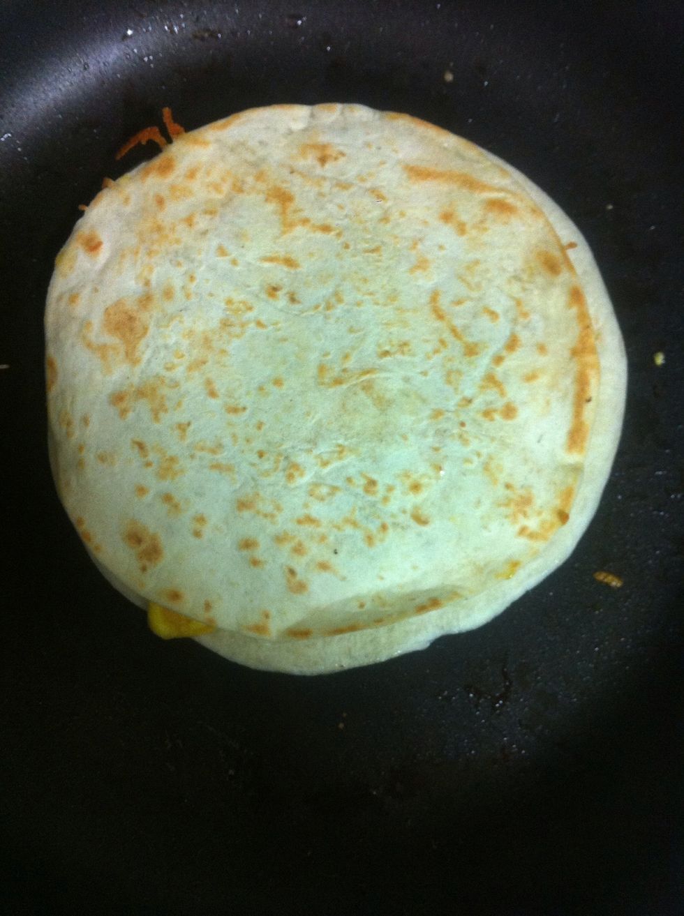 Place more cheese on top of the egg and the other tortilla. Then flip it over