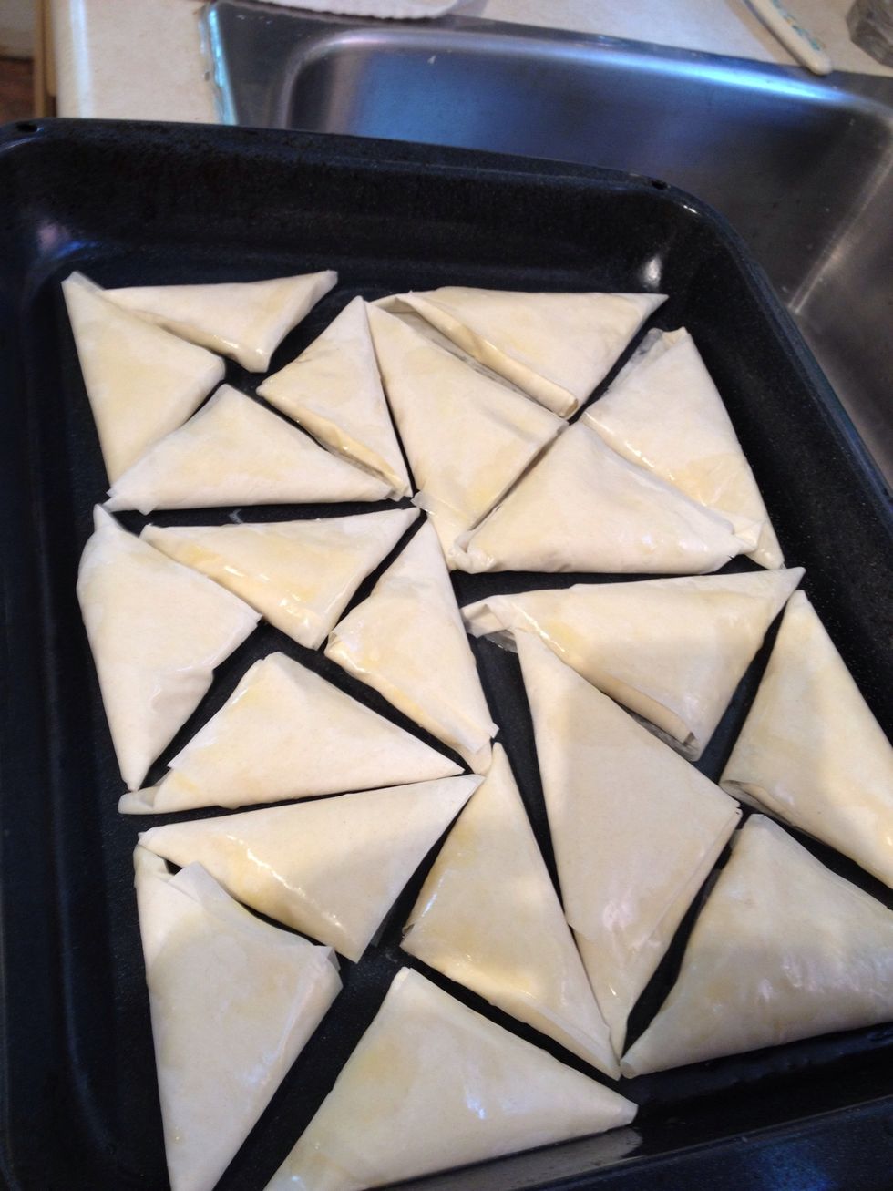 Place on a buttered tray. Also, brush butter on each side of tiropitas. Leave in oven for 20minutes. Then set to broil. But pay close attention! They can burn easily. Take out when their golden.